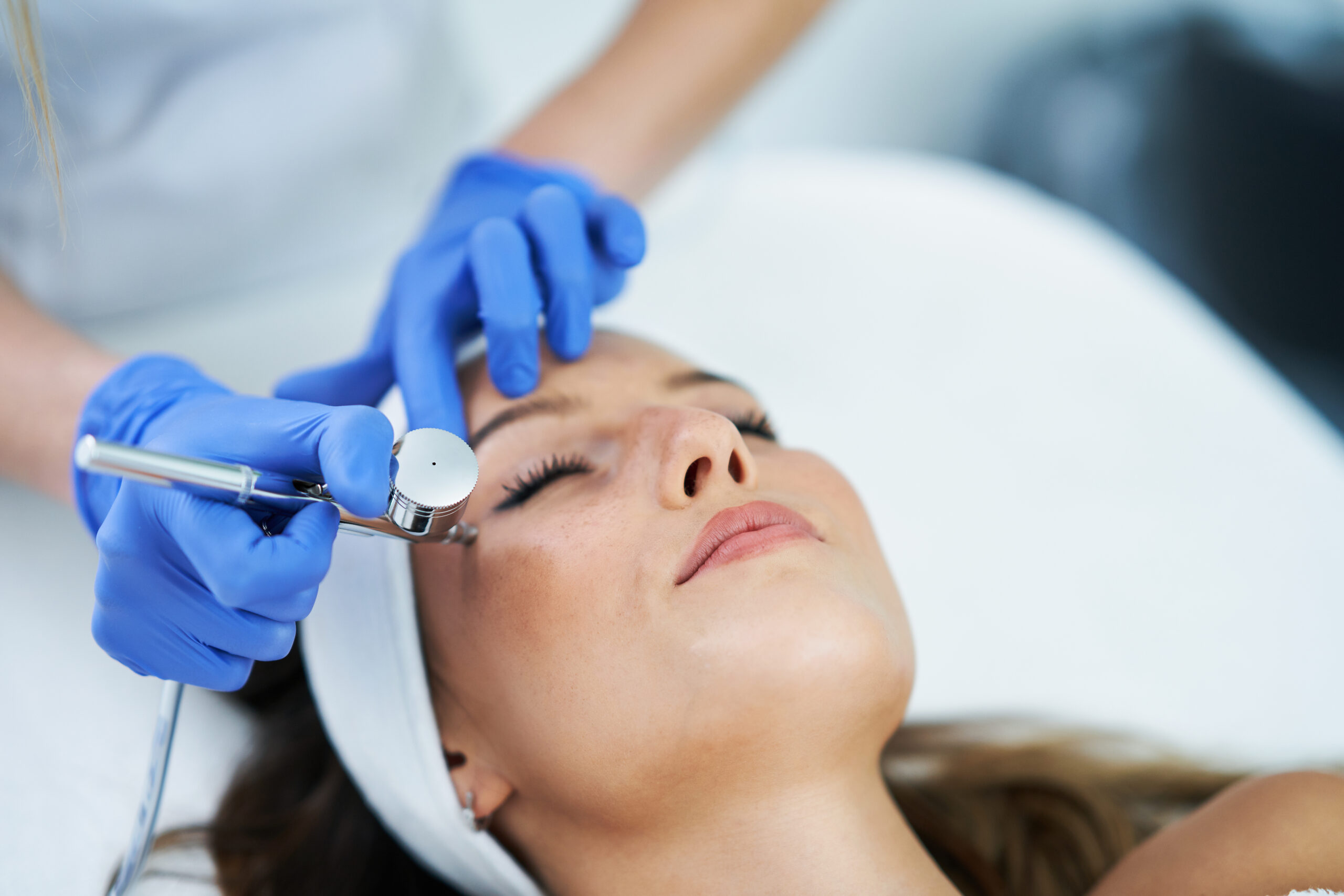 Beautiful young woman getting a face treatment at beauty salon.